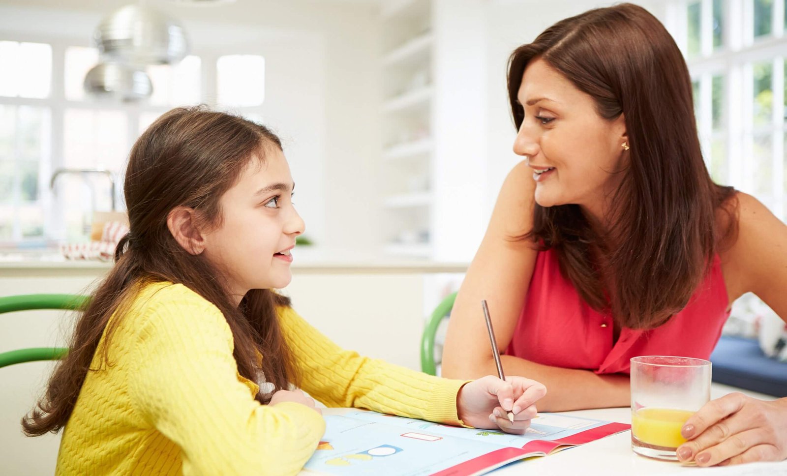 Maria with her daughter doing homework at the kitchen table in 2025, supported by a Latte Loans title loan in Austin, TX, for back-to-school expenses.